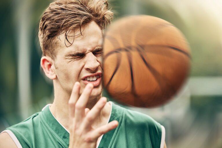 Sportler bekommt einen Ball ins Gesicht und erleidet eine Gehirnerschütterung. Concussion. play,bad,caucasian,professional,fit,basketball,hit,fitness,action,injury,sporty,athlete,impact,active,court,ache,closeup,person,competitive,sore,male,game,young,exercise,cardio,guy,training,tournament,exercising,sportsman,accident,head,ball,injured,uniform,trouble,man,physical,player,broken,pain,sports,center,match,centre,in pain,outdoor,face,workout,sport