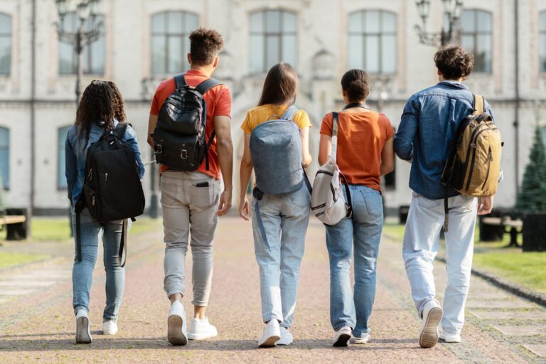 Fünf Studenten und Studentinnen sind auf dem Weg in die Universität zum Lehrgang Sportphysiotherapie. college,study,education,friendship,student,young,caucasian,university,back,students,togetherness,teens,youth,millennials,holding,school,academic,walking,casual,copy space,african american,diverse,international,five,leisure,group,break,females,going,learn,campus,degree,multiracial,friends,rear view,lifestyle,books,full length,outdoors,outside,backpack,guys,classmates,looking,millennial,multicultural,walk,women