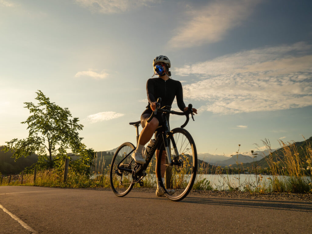 Frau mit Maske Spiroergometrie sitzt auf einem Rennrad