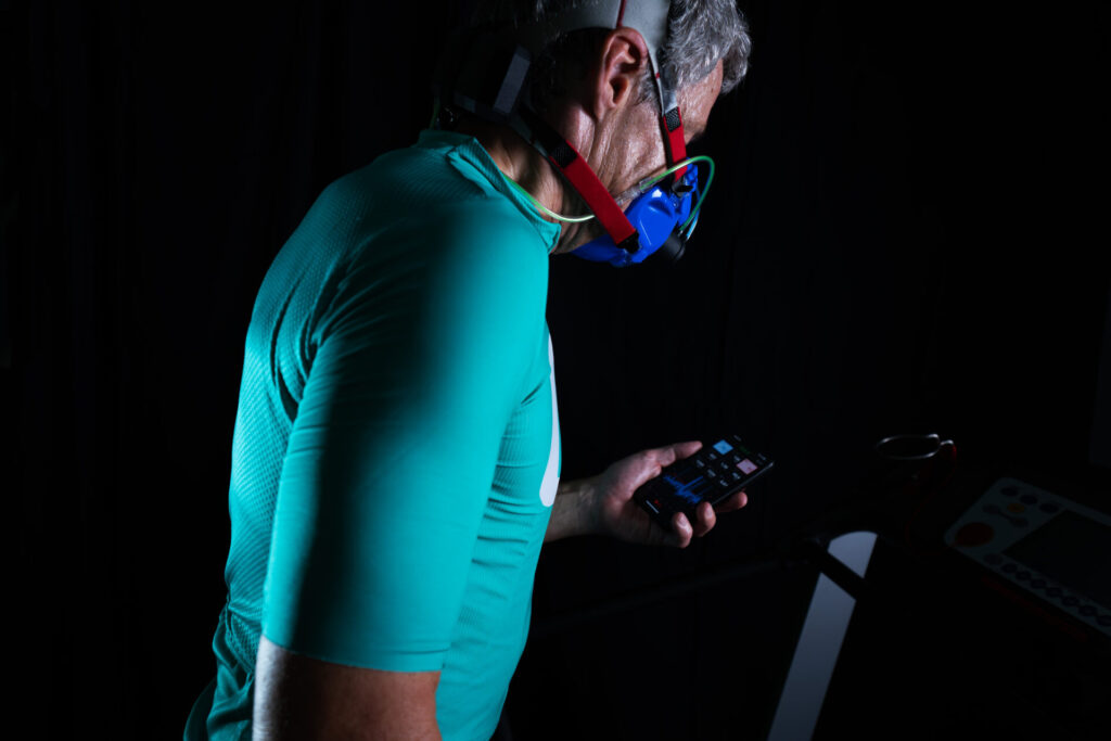 Mann mit mobiler Spirorgometrie Maske schaut sich die Ergebnisse via App auf seinem Handy an